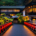 Red-painted pedestrian bridge at dusk leading to a traditional Japanese-style building with warm illuminated windows and lush greenery.